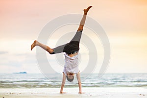 Teenager doing calisthenics exercise. Beach yoga photo