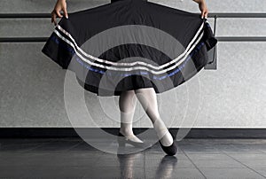 Teenager doing character ballet dance with skirt held in preparation