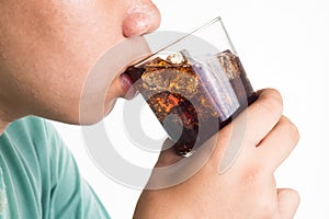 Teenager drinking a glass of refreshing cold fizzy cola drink