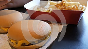 Teenager is eating fried french fries with onions and cheese. Hand punctures a plastic fork with unhealthy food or fast