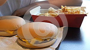 Teenager is eating fried french fries with onions and cheese. Hand punctures a plastic fork with unhealthy food or fast