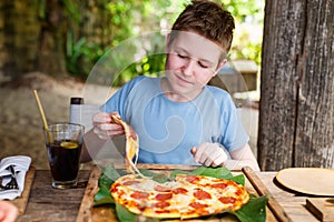 Teenager eating pizza