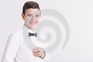 Teenager in elegant white shirt with paper dicky bow