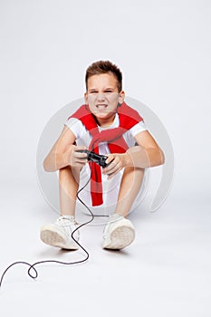 A teenager emotionally plays a computer or console game using the joystick