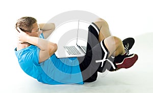 Teenager exercising while using his laptop