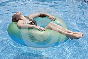 Teenager floating on float in pool