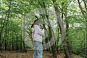 teenager gen z girl walking in the forest. close to nature concept