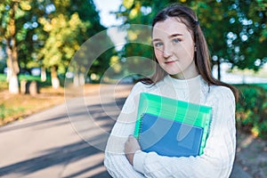 Teenager girl 14 years old autumn day summer city, hands notebooks folders with notes, happy smiling smart student