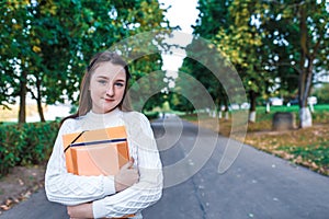 Teenager girl 15 years old autumn day summer city, hands notebooks folders with notes, happy smiling smart student