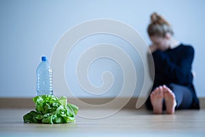 Girl with anorexia nervosa being on restricted diet of water and salad photo