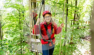 Teenager girl climbing in high rope course or parlor