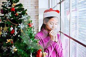 Teenager girl closed her eyes and folded her hand in prayer to wish in Christmas celebration