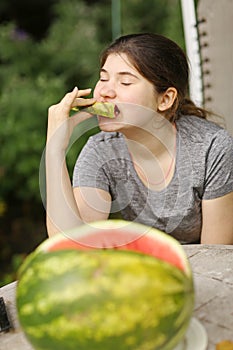 Teenager girl eat cut water melon slice close up photo