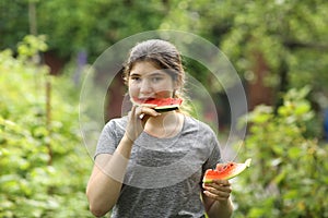 Teenager girl eat cut water melon slice close up photo