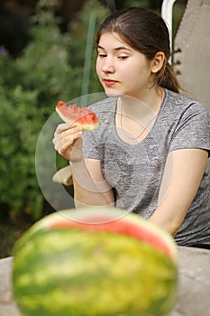 Teenager girl eat cut water melon slice close up photo