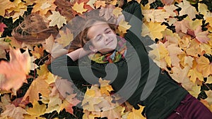 Teenager girl with falling autumn leaves