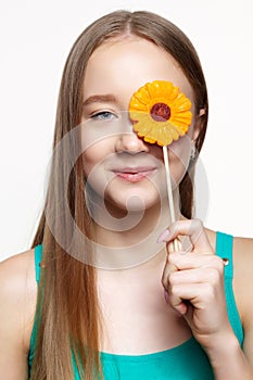 Teenager girl with flower lollipop in hands closing eye photo