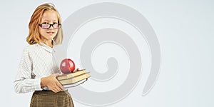 Teenager girl in glasses holding an apple and a book in her hands. Isolated background