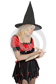 Teenager girl in Halloween witch reads magic book