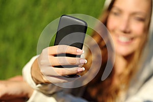 Teenager girl hand using a smart phone with her face in the background