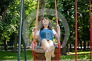 Teenager girl happiness female portrait on park outdoor children play ground with swing summer day