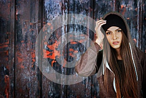 Teenager girl hipster on rusty fence background.