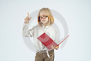 A teenager girl holding an open book in her hands and raised her finger up approvingly. Isolated background