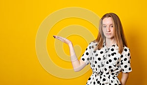 Teenager girl holds something in the palm. Young blonde girl is holding something in her hand copy space for advertising