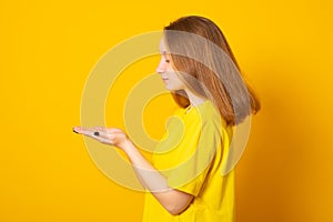 Teenager girl holds something in the palm. Young girl is holding something in her hand copy space for advertising