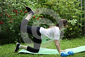 Teenager girl lift legs make exercises for flat stomack with dumbbell