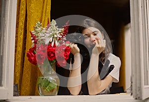 Teenager girl look out of the window at morning