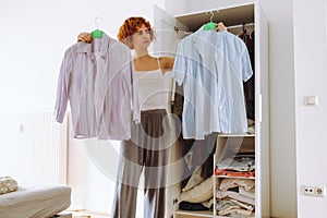 Teenager girl looking at clothes in wardrobe
