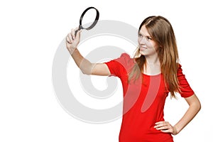 Teenager girl looking through the magnifying glass