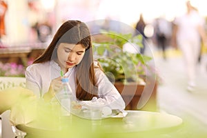 Teenager girl on lunch break sit in summer outdoor cafe