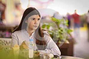 Teenager girl on lunch break sit in summer outdoor cafe