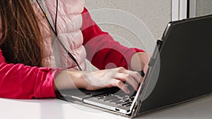 Teenager girl in mask and headphones, listening to music on laptop, chatting online, on open balcony. spring sunny day