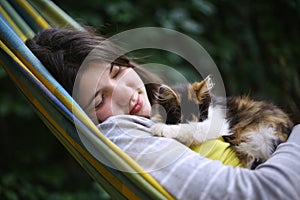 Teenager girl nap in hammock with little kitten