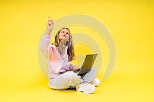 Teenager girl with notebok computer laptop sitting in studio photo