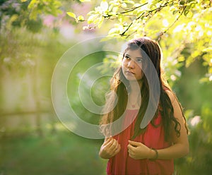 Teenager girl in pink summer fashion dress on green garden country background