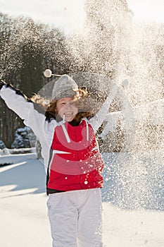 Teenager girl playing with snow in park