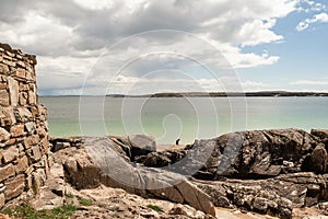 Teenager girl plays on the sand at Gurteen beach, county Galway, Ireland. Warm sunny day. Cloudy sky