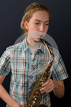 Cute teenage girl practicing saxophone photo
