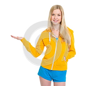 Teenager girl presenting something on empty palm