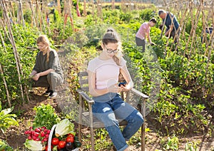 Teenager girl resting in garden using smartphone