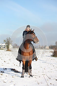 Teenager girl riding bay horse portrait