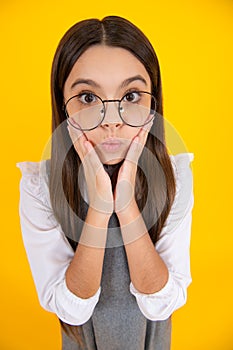 Teenager girl with shocked facial expression. Surprised face expression,  on yellow background.