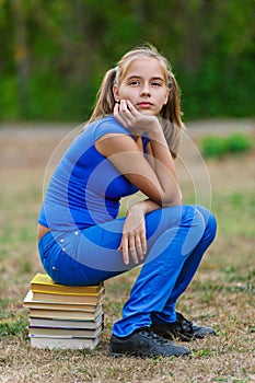 Teenager girl sitting on stack