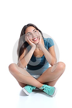 Teenager girl sitting and thinking looking sideways photo