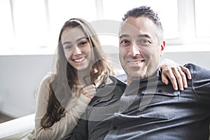 Teenager girl sitting on window with father