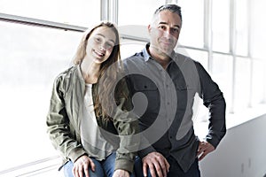 Teenager girl sitting on window with father